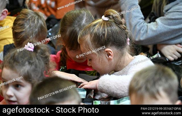 19 December 2023, Ukraine, Lysa Gora: Ukrainian girls and boys from an orphanage are delighted with Christmas presents brought by the private organization ""OHZ...