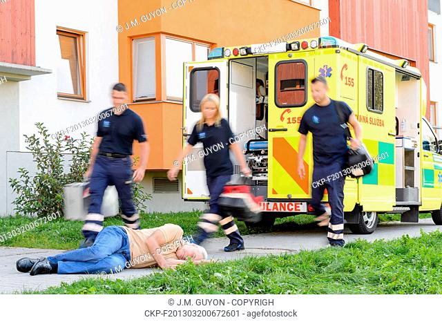 Paramedics hurrying helping senior man lying on the ground