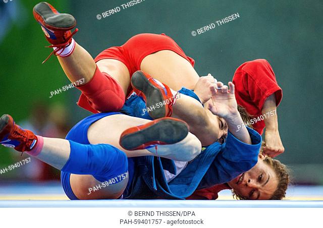 Yana Kostenko (red) of Russia and Katsiaryna Prakapenka (blue) of Belarus compete in the women's 60kg Sambo semi final match at the Baku 2015 European Games in...