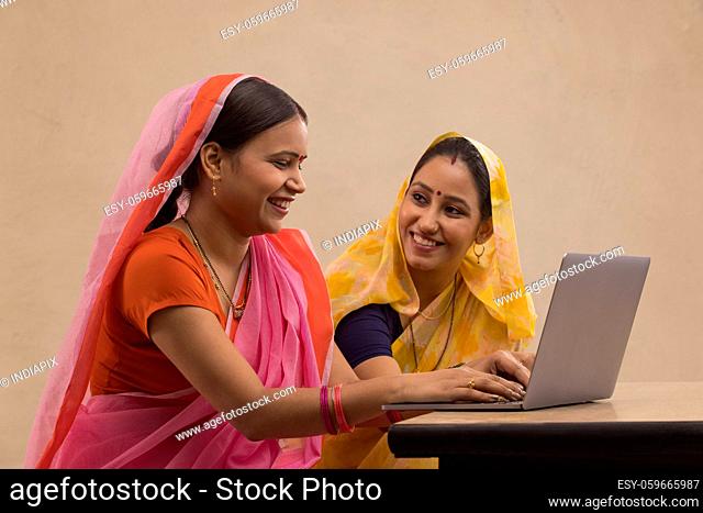 Two rural women sitting together with a laptop