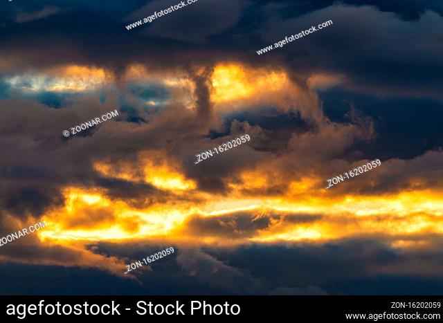 Beautiful dramatic clouds in sky illuminated by rays of sun at sunset to change weather. Colorful summer cloudscape abstract meteorology background