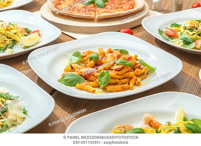 Set of fresh served pasta dishes and pizza. Italian food background