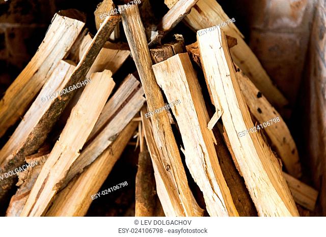 heating, warmth and coziness concept - close up of firewood in fireplace
