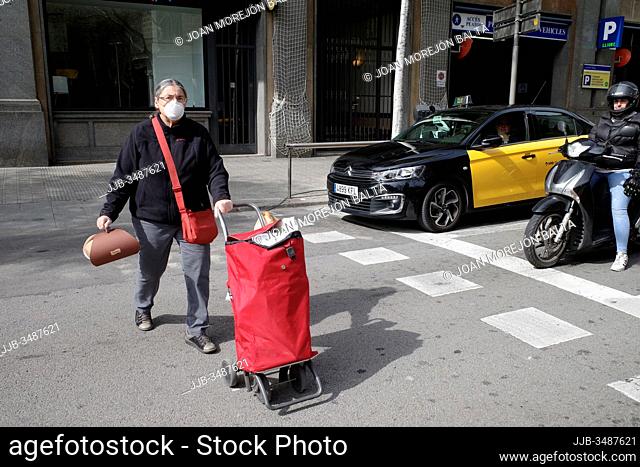 señora con la compra i mascara coronavirus con taxi barcelona