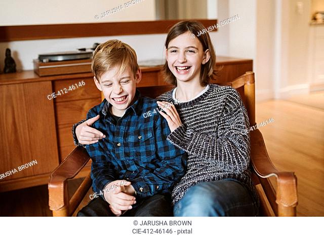 Portrait laughing tween brother and sister