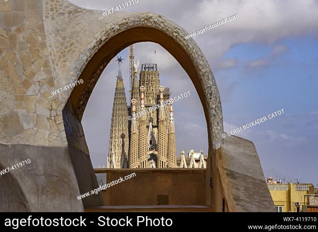 The Passion Facade of the Sagrada Família seen behind an arch of the Casa Milá  - La Pedrera (Barcelona, Catalonia, Spain)
