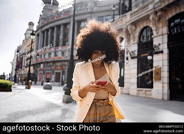 Woman using smart phone walking at street