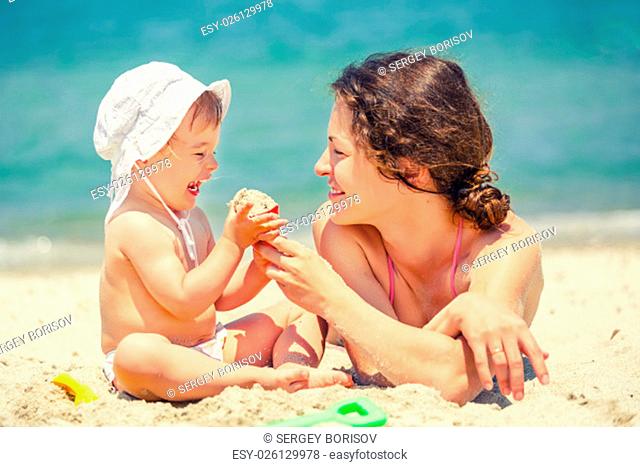 Mother with little daughter playing on the beach
