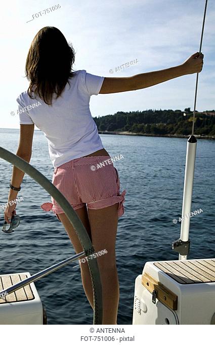 Rear view of a woman standing on a yacht