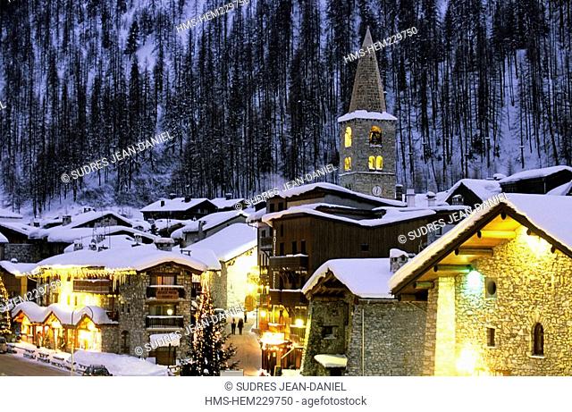 France, Savoie, Val d'Isere, view of the village and Saint Bernard de Menthon Church with a squared Lombard bell tower at dusk