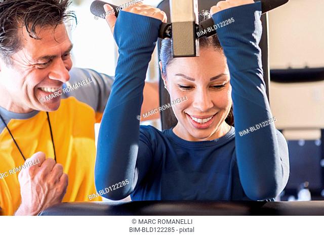 Woman working with personal trainer in gym