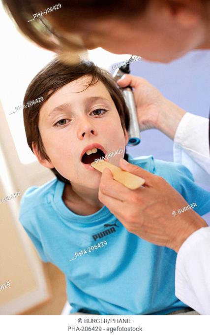 Doctor examining the throat of a 9 years old boy