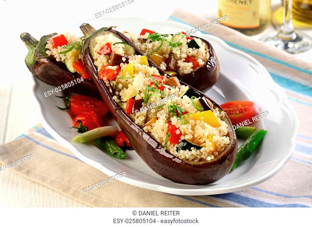 Roasted aubergine with savory filling of couscous with diced vegetables served on a platter for a delicious vegetarian meal