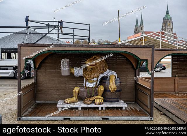 05 April 2022, Bavaria, Munich: A lion figure with a beer mug stands in a booth on Theresienwiese. It is to be placed in a beer tent for the upcoming spring...