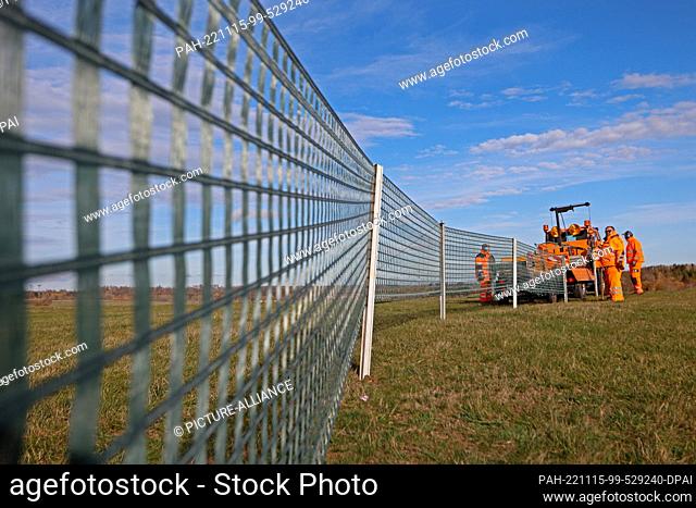 15 November 2022, Saxony-Anhalt, Elbingerode: Snow fences are erected by road maintenance staff on a country road near Elbingerode