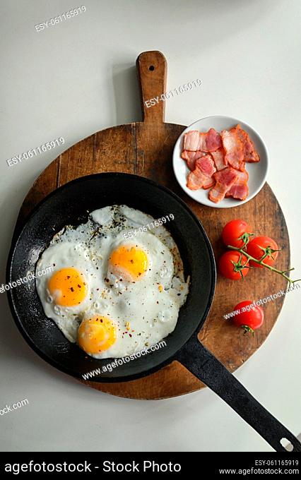 Fried Eggs In A Frying Pan, Bacon and Cherry Tomatoes