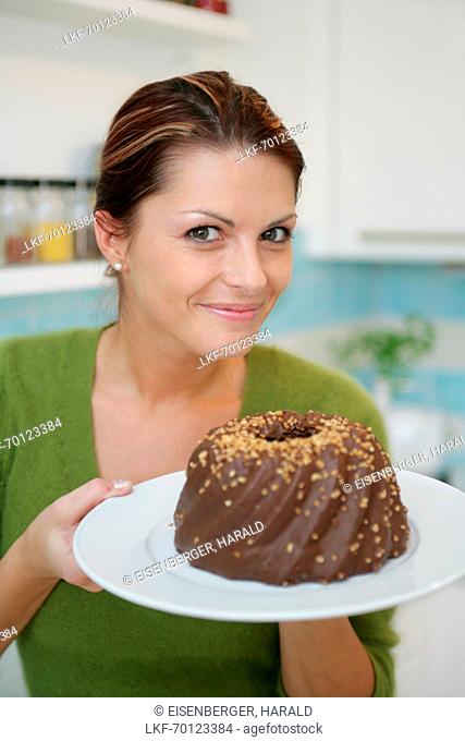 Young woman holding a chocolate cake, Munich, Germany