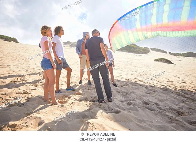 Paragliders with parachute on sunny beach