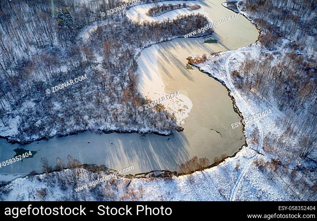 Aerial photo of Koen river under ice and snow. Beautiful winter landscape. Camera pointed down. Novosibirsk, Siberia, Russia