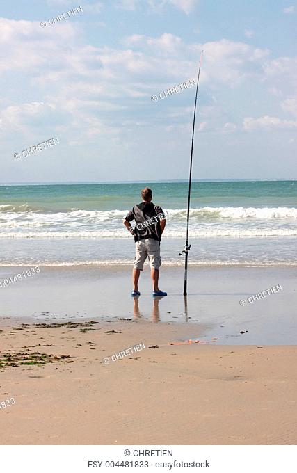 fisherman casting until the fish on a sandy beach