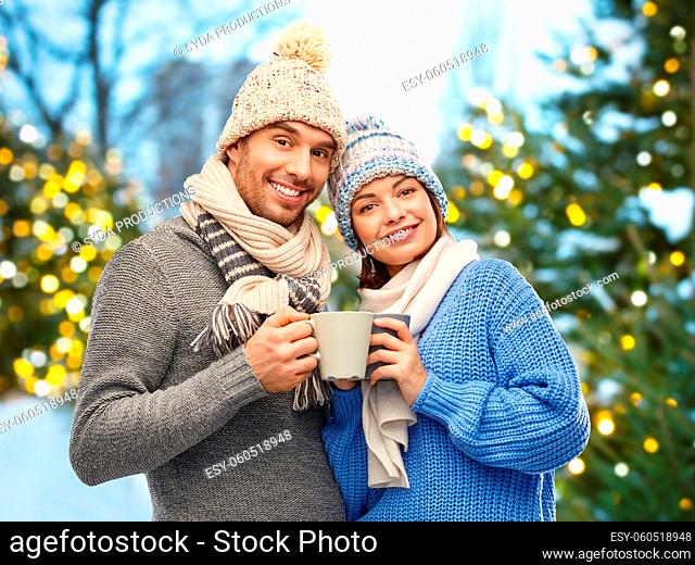 happy couple in winter clothes with mugs