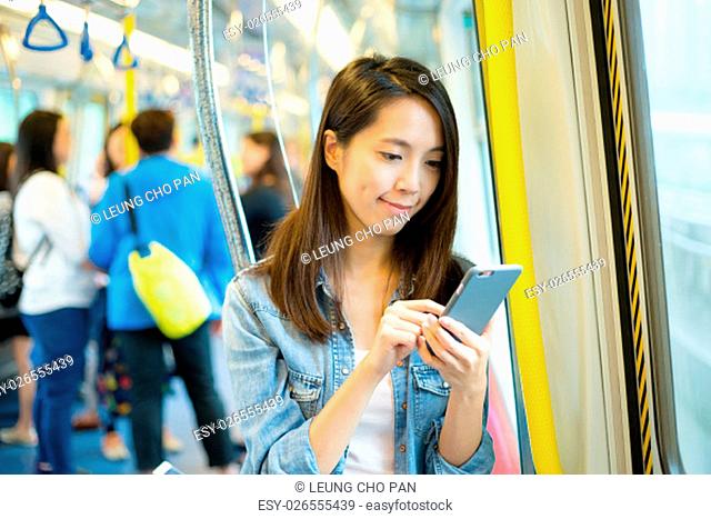 woman using cellphone inside train compartment