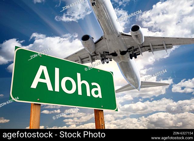 Aloha Green Road Sign and Airplane Above with Dramatic Blue Sky and Clouds