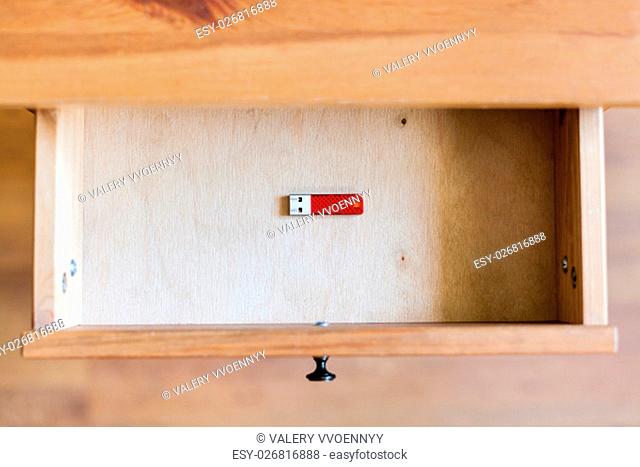 top view of little red flash drive in open drawer of nightstand