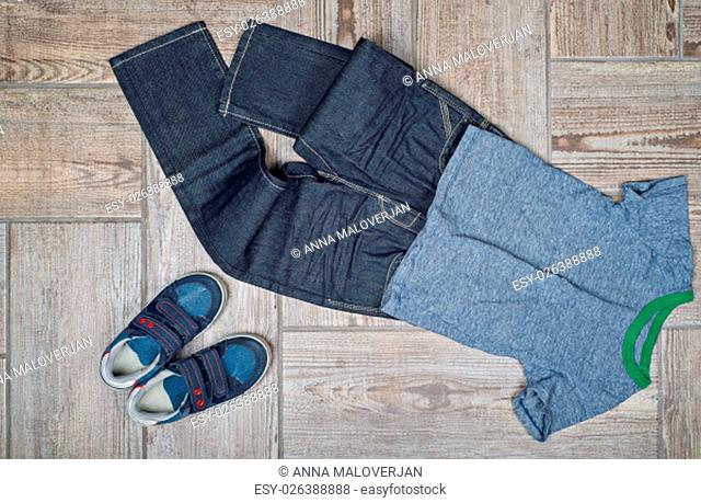 Flat lay photo of boy&#39;s casual outfit. Boy&#39;s casual outfit on wood board background