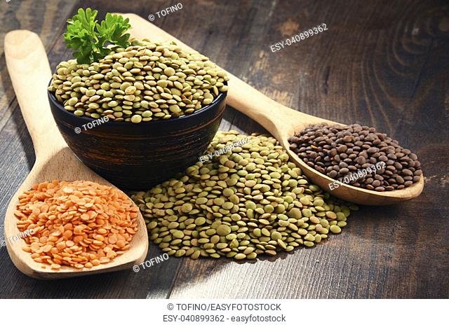 Composition with bowl of lentils on wooden table