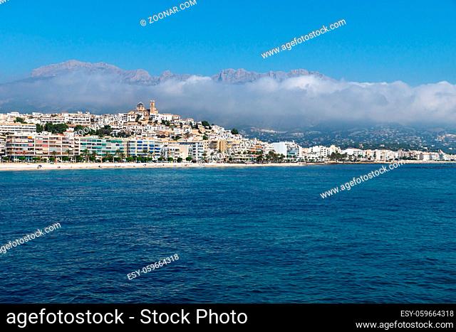 Panorama view over the ocean on the city of Altea along Costa Blanca coast with cloudy mountainrange, Spain