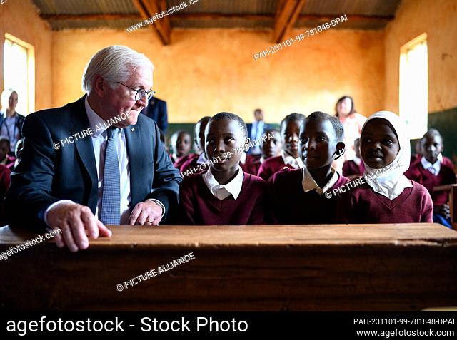 01 November 2023, Tanzania, Songea: German President Frank-Walter Steinmeier sits next to schoolgirls in a class at Maji-Maji Primary School in Songea