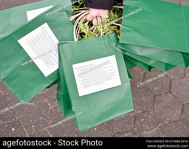 02 April 2020, North Rhine-Westphalia, Gelsenkirchen: Consecrated boxwood branches are in the bags for home. The catholic parish Hippolytus offers a bag for the...