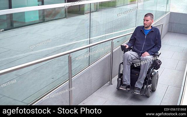 man on electric wheelchair using a ramp. Accessibility concept