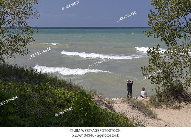 Beverly Shores, Indiana - A man and woman on the beach at Indiana Dunes National Lakeshore, at the southern end of Lake Michigan