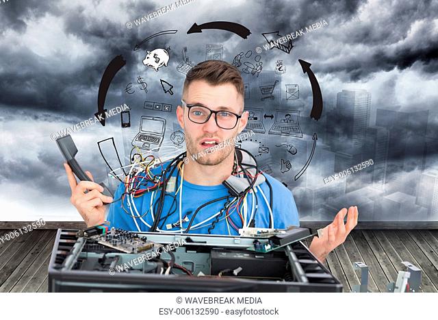 Composite image of confused it professional with cables and phone in front of open cpu