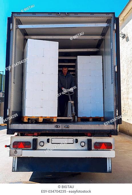 Worker loads white semi-truck