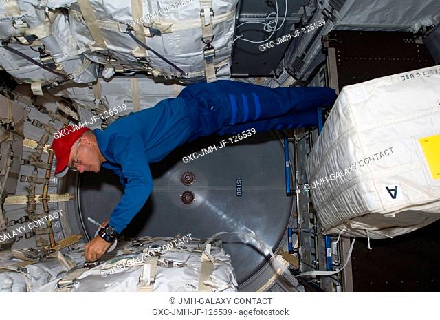NASA astronaut Rick Sturckow, STS-128 commander, works in the Leonardo Multi-Purpose Logistics Module (MPLM), temporarily attached to the International Space...