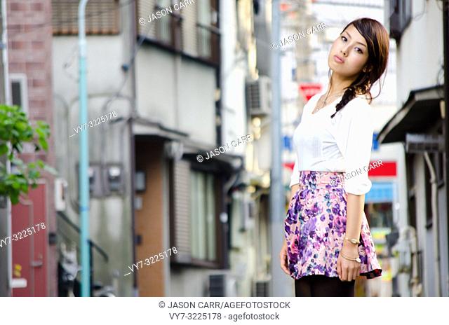 Japanese Girl poses on the street in Nakameguro, Japan. Nakameguro is a town located in the nice area of Tokyo