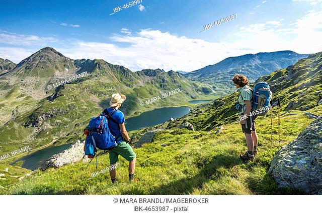 Hikers look down into the valley on the Giglachsee lakes, Schladminger Höhenweg, Schladminger Tauern, Schladming, Styria, Austria