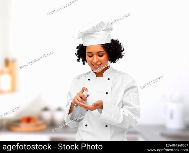 female chef applying hand sanitizer or liquid soap
