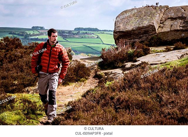 Young man hiking on crocodile rock, Pateley Bridge, Nidderdale, Yorkshire Dales