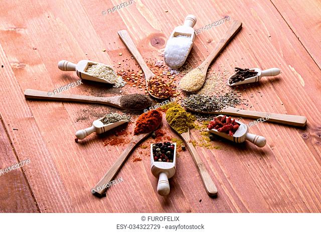 assortment of diferent color spices on wooden table