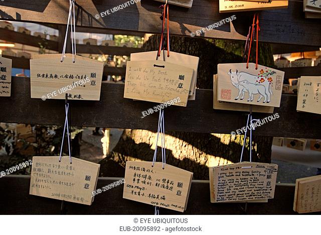 Jingumae - at Meijijingu shrine, ema wooden cards with New Years resolutions and wishes written on them, some in English, decorated with year of cow