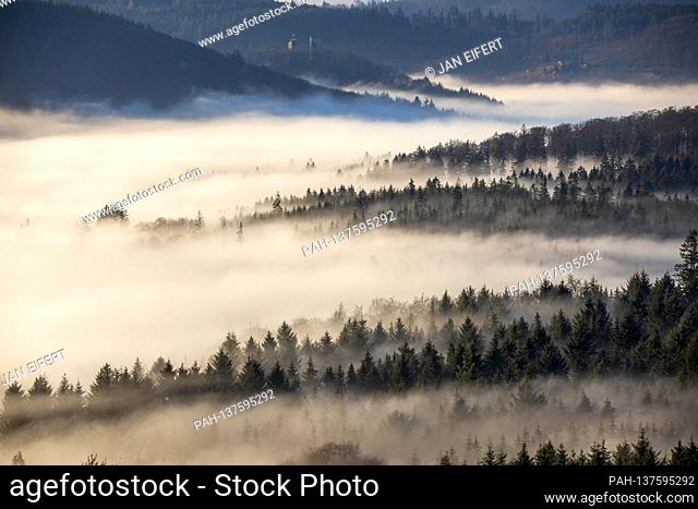 11/24/2020, Schwithten (Hessen): The high elevations of the Taunus with the Grosse Feldberg protrude from a sea of fog in the morning after sunrise