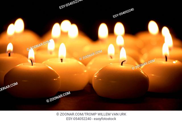 Group of burning candles at a black background with selective focus
