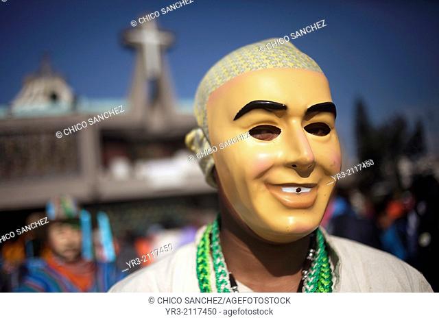 A dancer wearing a smiling masks from Los Altos, Veracruz, get ready to perform the Danza de San Juan at the pilgrimage to Our Lady of Guadalupe Basilica in...
