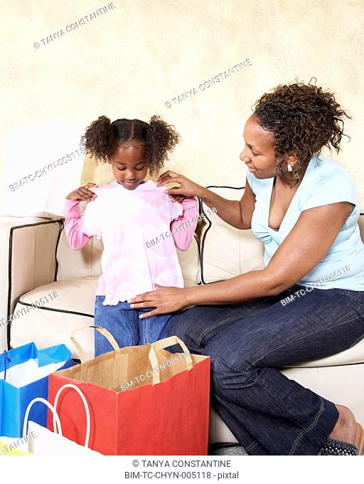 African mother showing young daughter new clothes