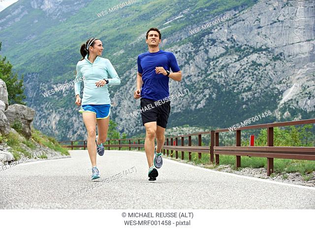 Italy, Trentino, couple running on road near Lake Garda