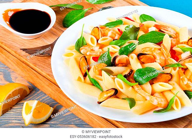 penne pasta salad with shrimps, mussels and baby spinach